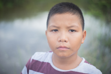 scared and alone, young  Asian child who is at high risk of being bullied, trafficked and abused, selective focusの写真素材