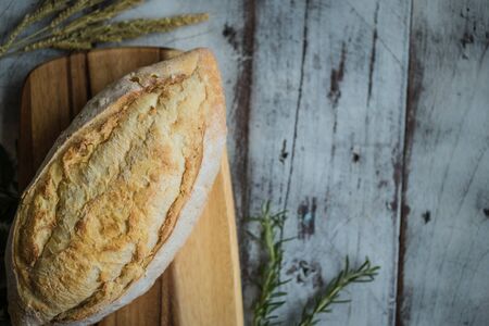 fresh bread and baked goods on wooden chopping board, rustic styleの写真素材