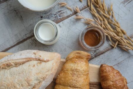 fresh bread and baked goods on wooden chopping board, rustic styleの写真素材