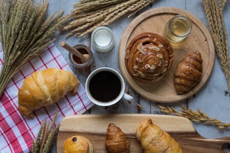 fresh bread and baked goods on wooden chopping board, rustic styleの写真素材