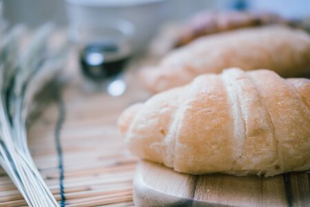 fresh bread and baked goods on wooden chopping board, rustic styleの写真素材