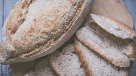 fresh bread and baked goods on wooden chopping board, rustic styleの写真素材