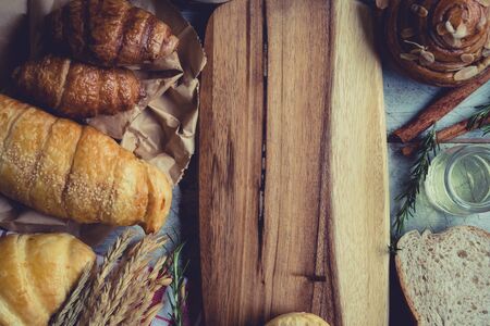 fresh bread and baked goods on wooden chopping board, rustic styleの写真素材