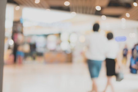 Shopping center with customers and seasonal sale promotions. Blurred, people unrecognizableの写真素材