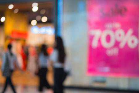 Shopping center with customers and seasonal sale promotions. Blurred, people unrecognizableの写真素材