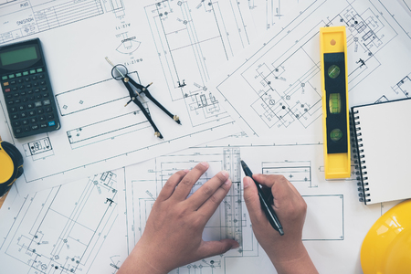 Architect or planner working on drawings for construction plans at a tableの写真素材