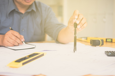Architect or planner working on drawings for construction plans at a table