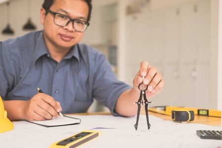 Architect or planner working on drawings for construction plans at a tableの写真素材