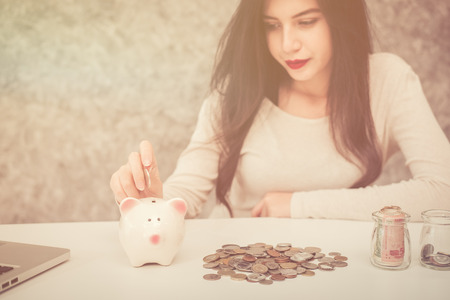 Beautiful young girl saving money for holiday season, saving money conceptの写真素材