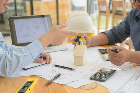Architect or planner working on drawings for construction plans at a tableの写真素材