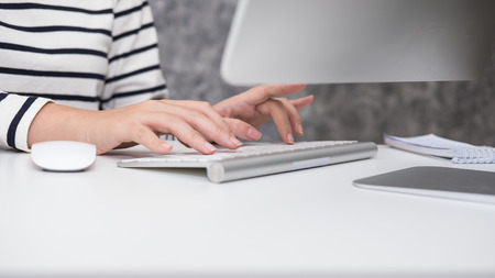 Young beautiful girl working on the laptop at the office aloneの写真素材