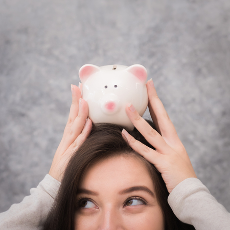 Beautiful young girl saving money for holiday season, saving money conceptの写真素材
