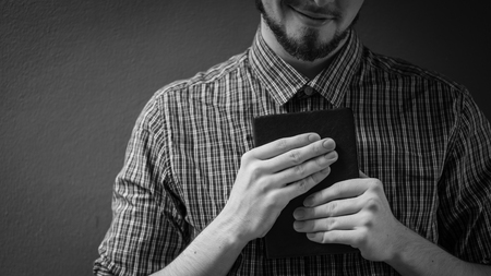 Closeup on a man holding a bible at shopping mall, believe concept