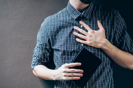 Closeup on a man holding a bible at shopping mall, believe conceptの写真素材