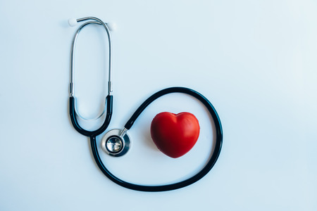 close up red heart and stethoscope on white background, world health day concept, process vintage...