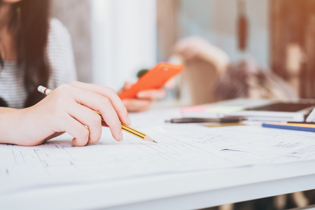 Architect or planner working on drawings for construction plans at a tableの写真素材