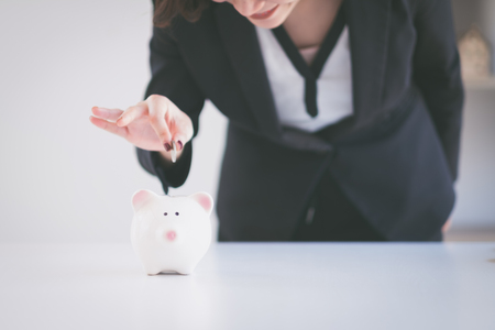 Beautiful young business girl saving money for holiday season, saving money conceptの写真素材