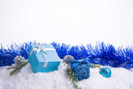 Christmas decorations - Gift box balls, pine cones and green branch on snow white backgroundの写真素材