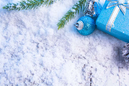 Christmas decorations - Gift box balls, pine cones and green branch on snow white woodの写真素材
