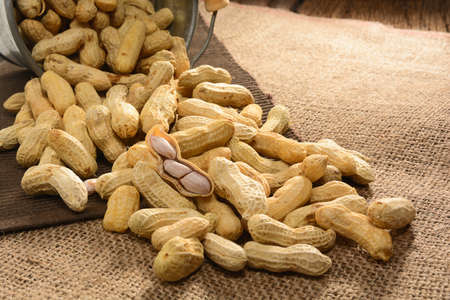 Boiled peanuts in zinc bucket on brown fabric top of wooden table