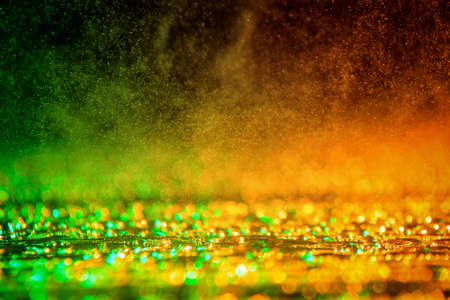 abstract twinkled background with bokeh defocused green / orange light