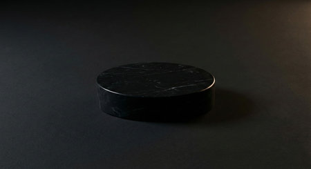 A minimalist cylindrical black marble pedestal with white veining, presented on a dark background. Ideal for product display or abstract composition.の素材