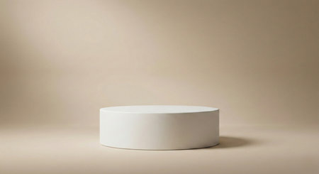 A pristine white cylindrical pedestal centered on a warm, neutral beige background, softly illuminated by an overhead spotlight. An ideal stage for premium product photography.の素材