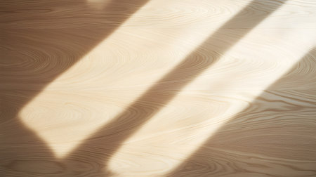 Bright sunlight casts dramatic diagonal shadows across a lighttoned wooden floor. The warm glow highlights the natural grain, creating a serene and inviting atmosphere.の素材