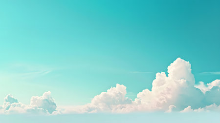 Bright white cumulus clouds stretch across a wide turquoise sky, creating a feeling of openness and tranquility. The clear horizon line offers a sense of boundless freedom.の素材
