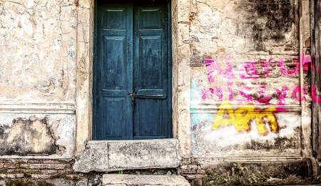 Decorative blue door on an old paint wallの写真素材