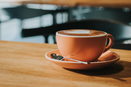 Hot coffee in cup on wood table soft focus, toned retro effect.の写真素材