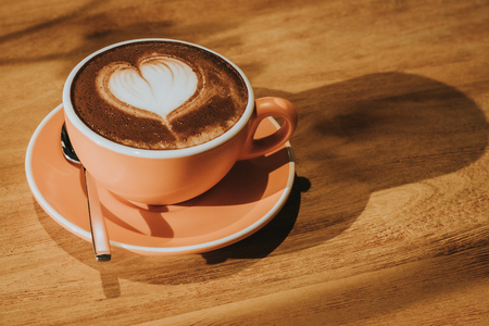 Hot coffee in cup on wood table soft focus, toned retro effect.の写真素材