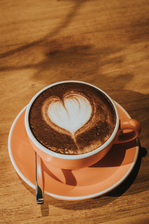 Hot coffee in cup on wood table soft focus, toned retro effect.の写真素材