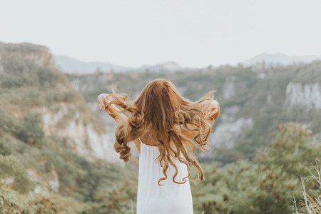 Rear view of beautiful young girl fabulous hair in a field. happy holiday