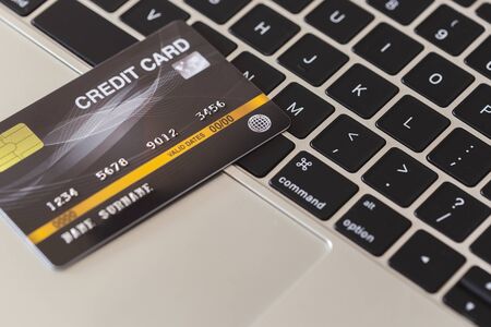 close up black credit card on laptop of business workplace.の写真素材