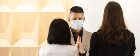 business man wearing medical mask greeting thailand style instead of handshake for prevent infection...