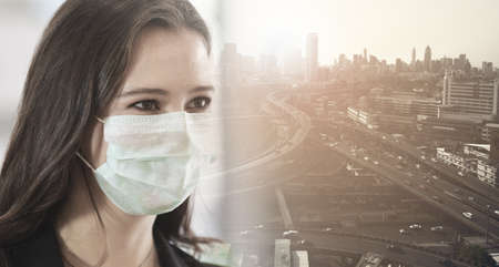 Business women wearing hygienic mask prevent dust and virus, Double exposure cityscape.の写真素材
