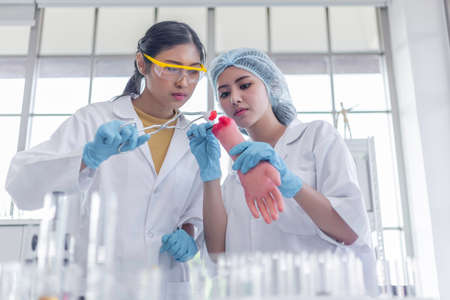 asian woman's students nurse intern medical cleaning wound with cotton with arm model in hospital. learning for work future.の写真素材