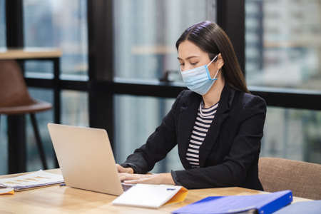 Asian businesswoman wear masks protect against airborne disease and salivary infections, during...