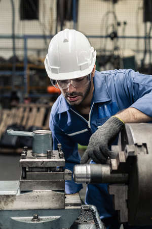 Engineer men wearing uniform safety in factory working machine lathe metal.