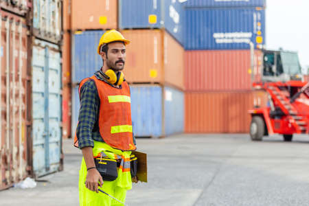 Foreman using radio communication control loading containers
in shipping yard, for logistics and import export company. business logistics concept.の写真素材