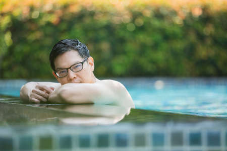 asian handsome man relax time at poolside, lifestyle travel in holiday vacation. relaxation concept.