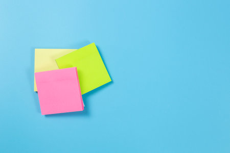 Stack empty sticky post note paper sheet on blue background.の写真素材