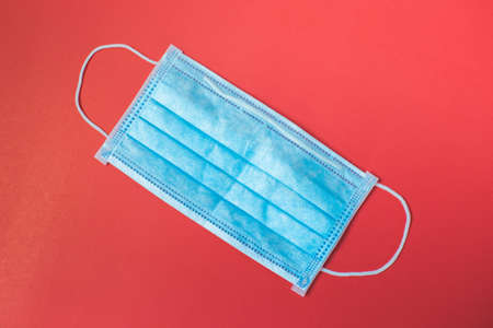 Blue hygienic mask on red background. using for dust and virus.の写真素材