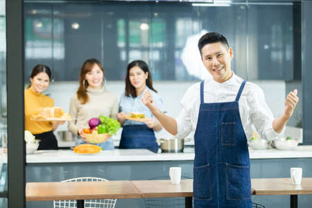 happy asian man chef and woman cooking together in kitchen.の写真素材