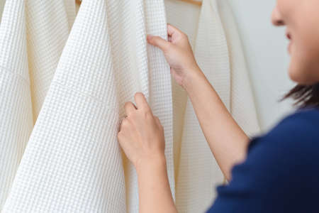 woman room maid adjusting bathrobe in hotel. staff bedroom hotel.の写真素材