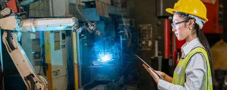 asian woman engineer worker use tablet control robot automatic, Factory Industry automatic system software. automotive robotics.の写真素材