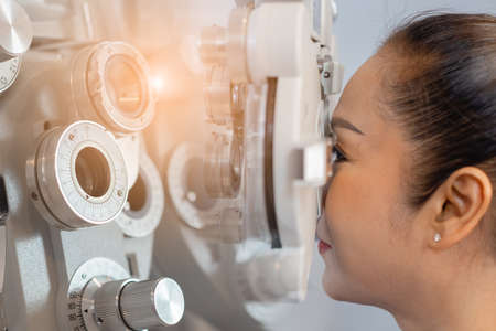 Close up asian middle age woman eye exam with diagnostic ophthalmology in optical clinic....