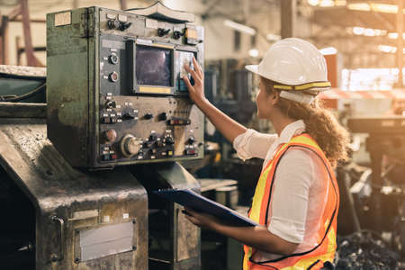 Female engineer wearing uniform safety are checking system machine in factory. Workers industrial factory.の写真素材