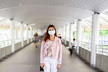 asian woman wearing medical mask for prevent dust and infection virus standing in city.の写真素材